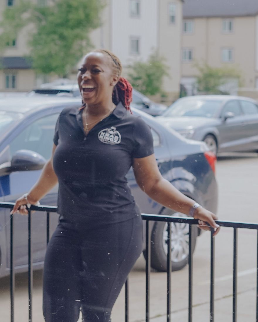 Krab Kingz team member in a branded polo laughing at the front window